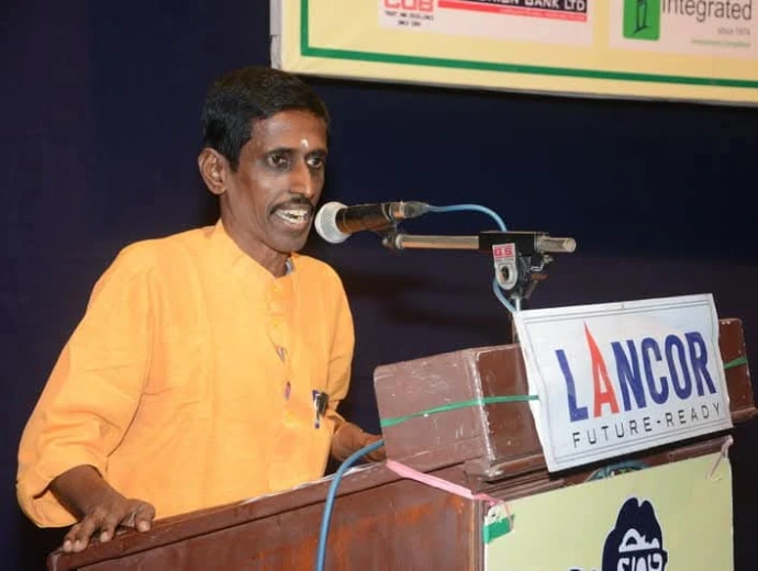 "Sirippoli Chidambaram delivering a speech at a podium"